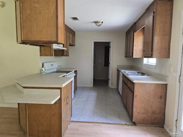 kitchen with light countertops, white electric range oven, under cabinet range hood, and visible vents