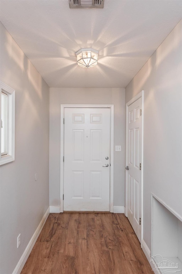 308 Twisted Oak Dr, Cantonment, FL 32533 - doorway featuring visible vents, baseboards, and wood finished floors
