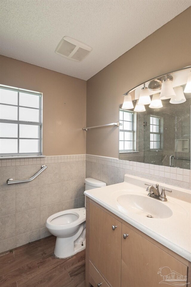 308 Twisted Oak Dr, Cantonment, FL 32533 - full bathroom featuring vanity, toilet, a shower stall, tile walls, and wood finished floors