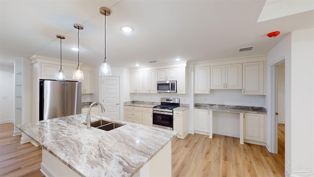 kitchen featuring visible vents, appliances with stainless steel finishes, light wood-style floors, and a sink