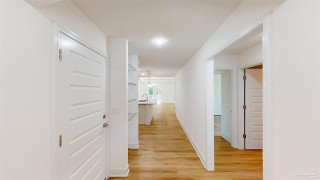 corridor featuring recessed lighting, light wood-type flooring, and baseboards