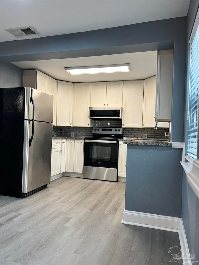 kitchen with stainless steel appliances, light hardwood / wood-style floors, white cabinetry, and tasteful backsplash