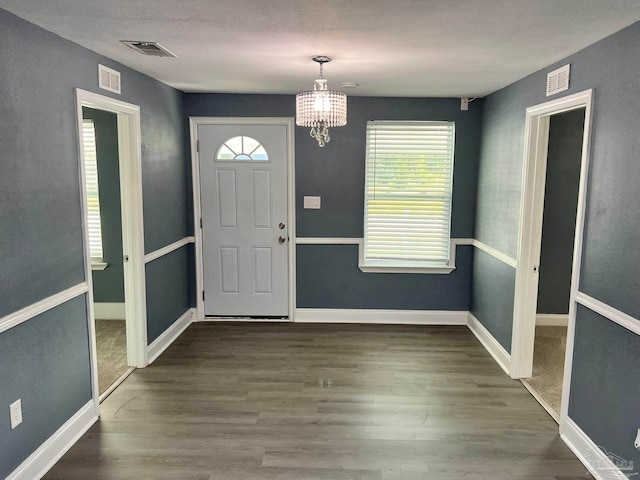 entryway featuring a notable chandelier and dark hardwood / wood-style floors