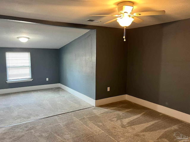 carpeted spare room with ceiling fan and a textured ceiling