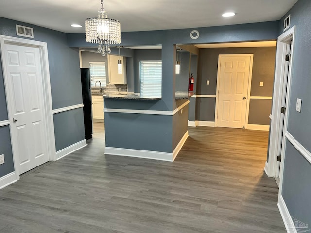 kitchen with dark hardwood / wood-style flooring, white cabinets, sink, backsplash, and decorative light fixtures