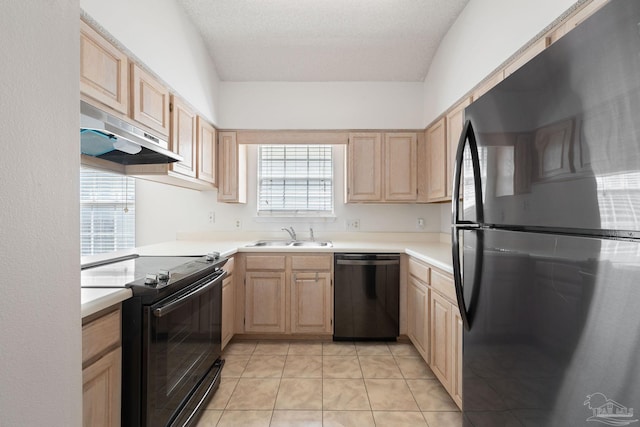 kitchen with black appliances, light brown cabinetry, light countertops, and under cabinet range hood