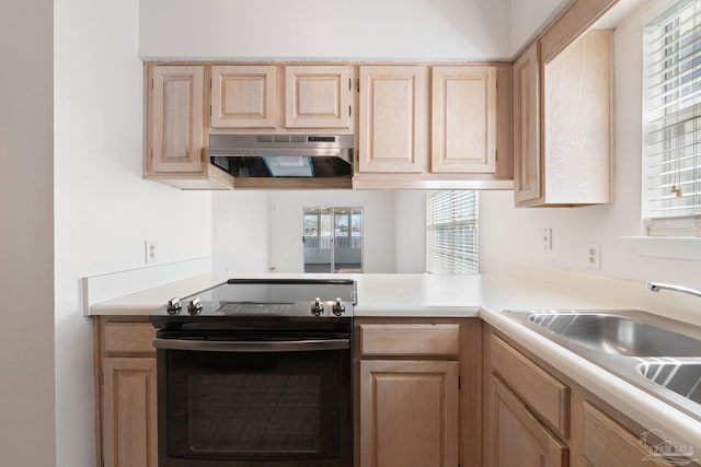 kitchen with light countertops, electric range oven, light brown cabinetry, a sink, and under cabinet range hood