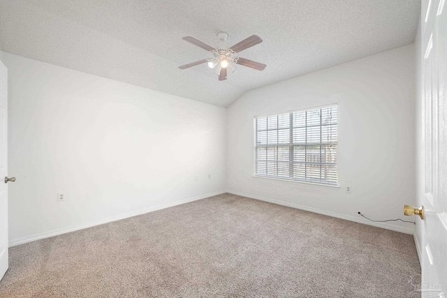 unfurnished room featuring a textured ceiling, ceiling fan, carpet flooring, baseboards, and vaulted ceiling