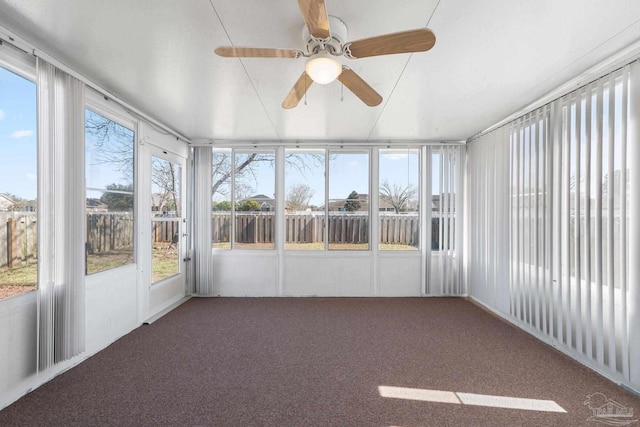 unfurnished sunroom featuring ceiling fan and a wealth of natural light