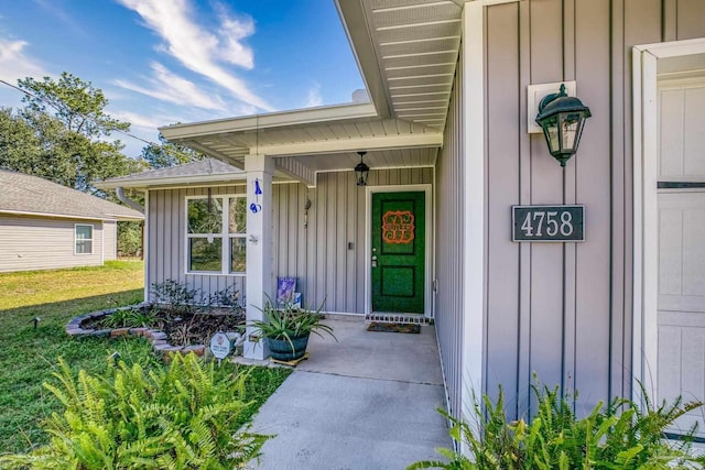 property entrance featuring a yard and board and batten siding