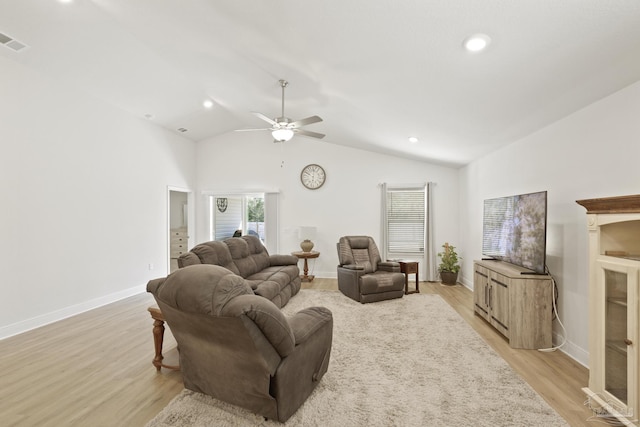 living room featuring light wood-type flooring, visible vents, baseboards, and vaulted ceiling