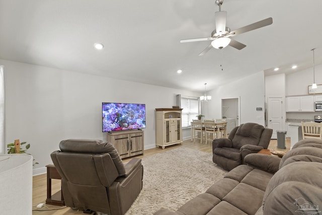 living area featuring vaulted ceiling, ceiling fan with notable chandelier, light wood-style flooring, and recessed lighting