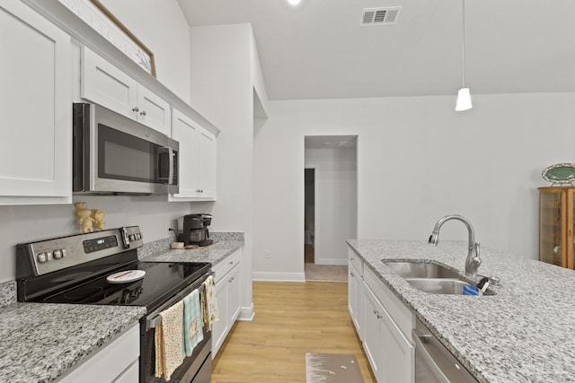 kitchen featuring light wood finished floors, visible vents, appliances with stainless steel finishes, white cabinetry, and a sink