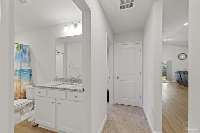 full bathroom with toilet, vanity, visible vents, and baseboards