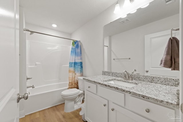 full bathroom with visible vents, toilet, wood finished floors, shower / bathtub combination with curtain, and vanity