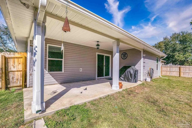 back of property with fence, a lawn, and a patio