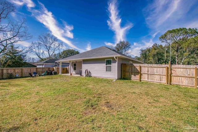 back of property featuring a fenced backyard and a lawn