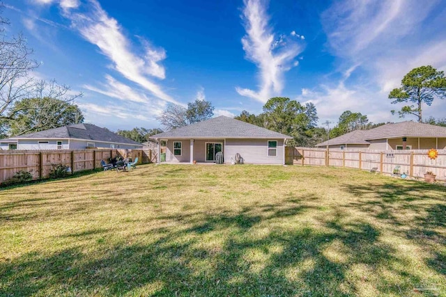 back of property featuring a fenced backyard and a lawn