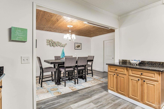 dining room featuring baseboards, ornamental molding, wood ceiling, light wood-style floors, and a notable chandelier