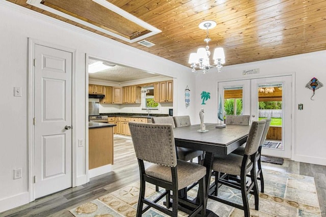 dining area with visible vents, french doors, light wood-style floors, an inviting chandelier, and wood ceiling