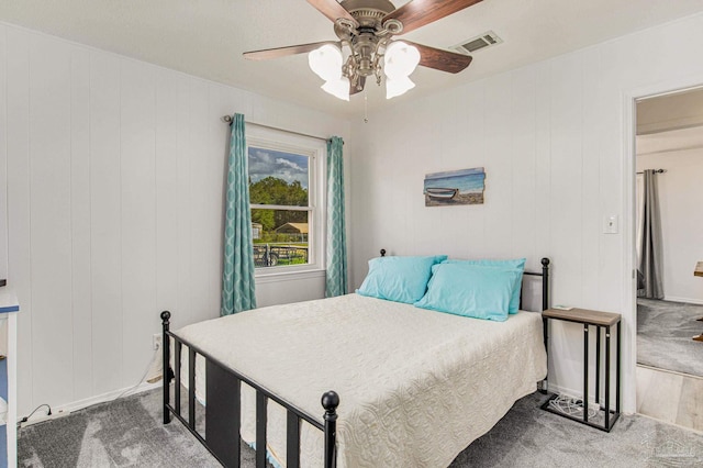 carpeted bedroom featuring a ceiling fan and visible vents