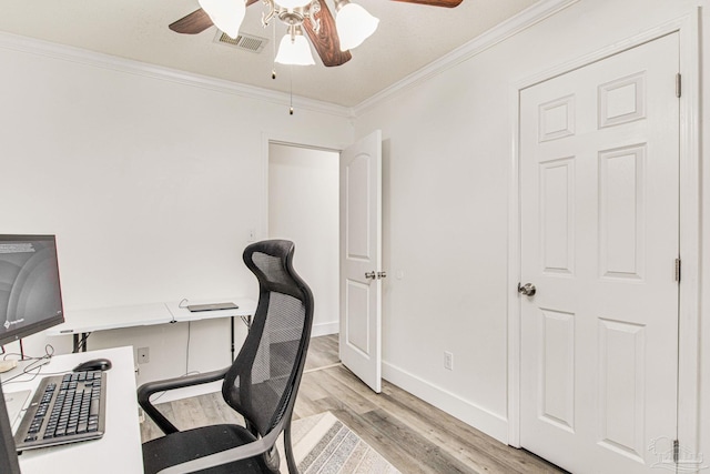 office area with light wood finished floors, visible vents, baseboards, ornamental molding, and a ceiling fan