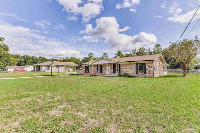 ranch-style house featuring brick siding, a carport, a front yard, and fence