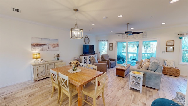 dining space featuring crown molding, ceiling fan, and light wood-type flooring