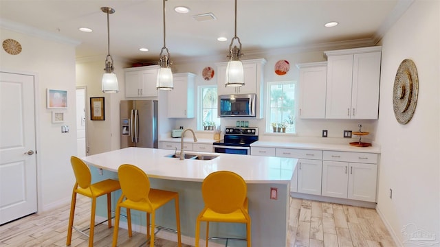 kitchen with stainless steel appliances, white cabinetry, sink, and a center island with sink