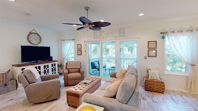 living room featuring crown molding, light hardwood / wood-style flooring, and ceiling fan