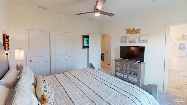 bedroom featuring crown molding, light colored carpet, ceiling fan, and a closet