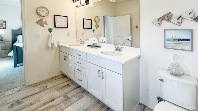 bathroom with hardwood / wood-style flooring, vanity, and toilet