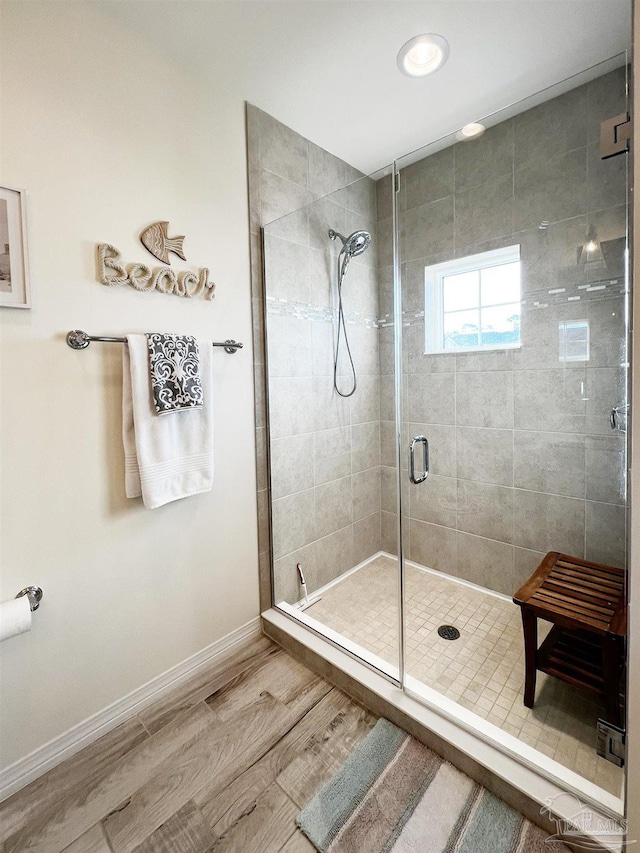 bathroom featuring a shower with shower door and wood-type flooring