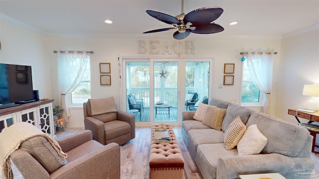 living room featuring ornamental molding, light hardwood / wood-style floors, and ceiling fan