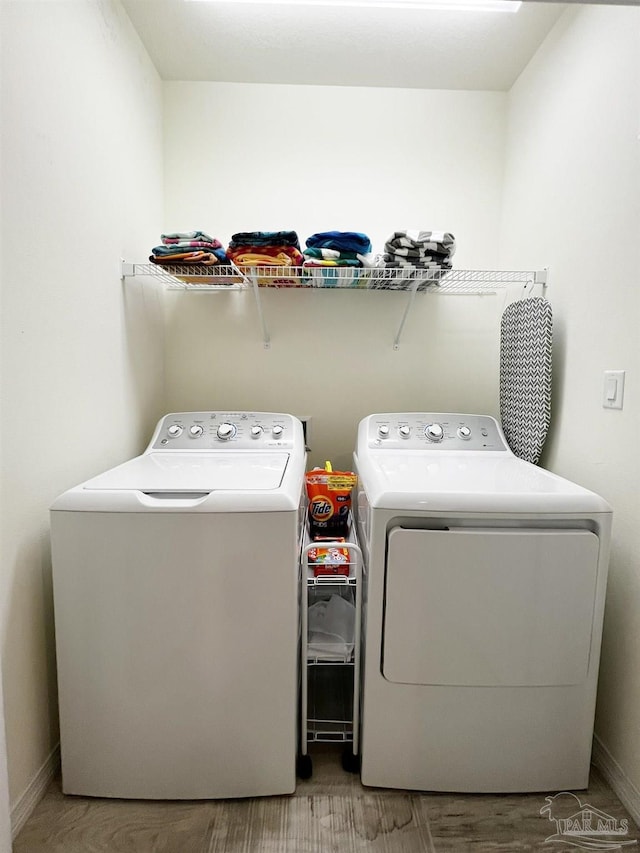 laundry room featuring hardwood / wood-style flooring and washing machine and clothes dryer