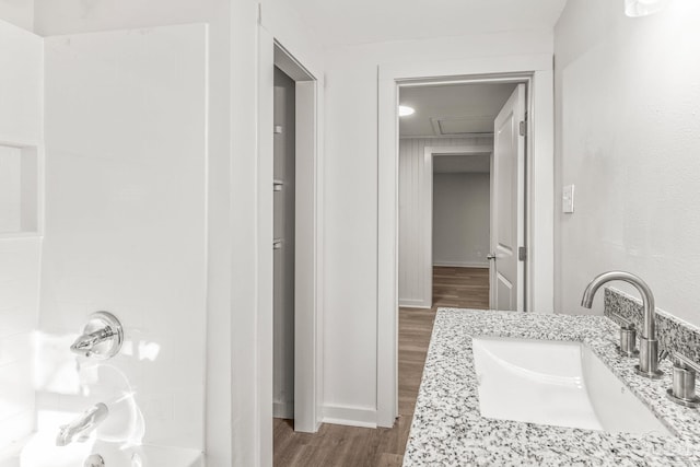 bathroom with a tub to relax in, hardwood / wood-style floors, and vanity