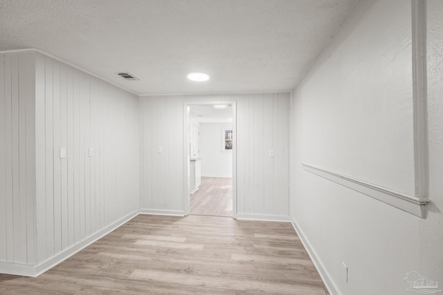 hallway featuring a textured ceiling and light hardwood / wood-style flooring