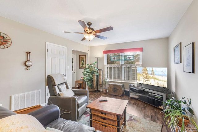 living room with a ceiling fan, visible vents, and wood finished floors