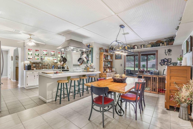 dining area featuring light tile patterned floors, ceiling fan, and baseboards