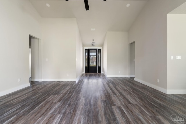 unfurnished living room with baseboards, a ceiling fan, and dark wood finished floors
