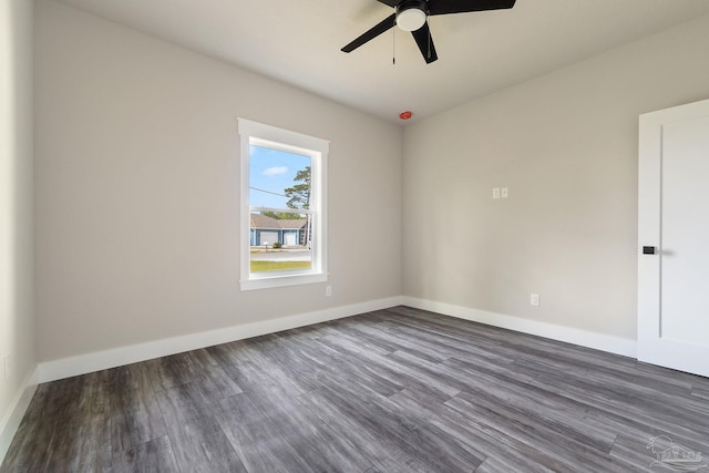empty room featuring dark wood-style flooring, ceiling fan, and baseboards