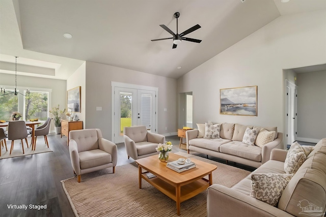 living room featuring high vaulted ceiling, plenty of natural light, ceiling fan with notable chandelier, and dark wood-style floors