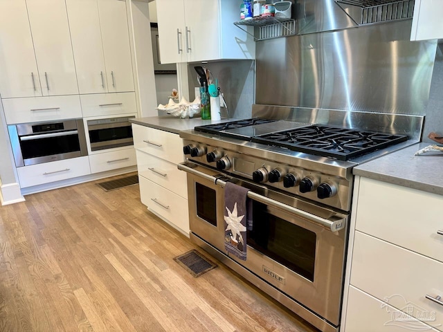 kitchen featuring appliances with stainless steel finishes, white cabinetry, and light wood-type flooring