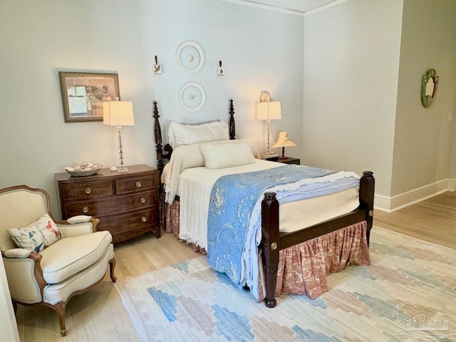 bedroom featuring ornamental molding and light wood-type flooring