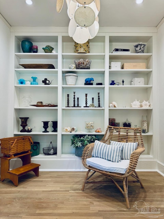 sitting room featuring hardwood / wood-style flooring and built in features