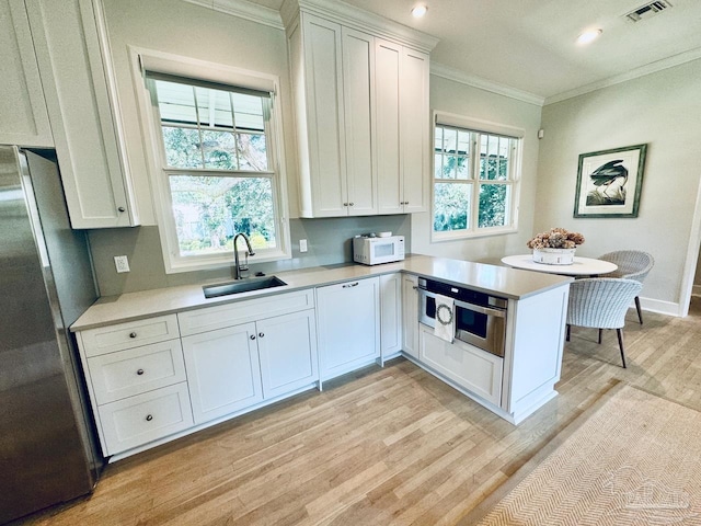 kitchen featuring white cabinetry, stainless steel appliances, sink, and kitchen peninsula