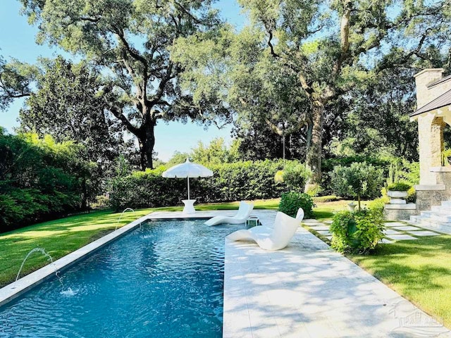 view of pool with a patio area, pool water feature, and a lawn