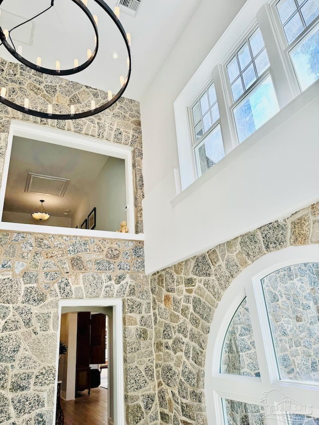 stairway featuring hardwood / wood-style floors, a chandelier, and a high ceiling