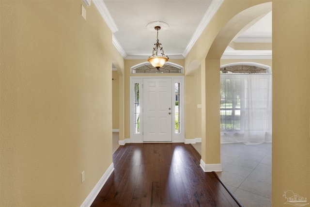 entrance foyer with ornamental molding and dark wood-type flooring