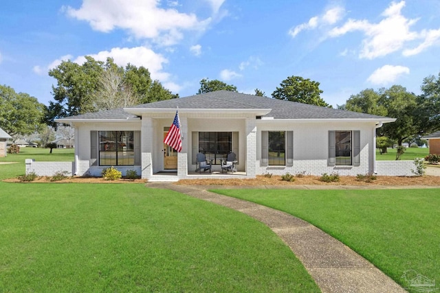 view of front of home with brick siding, a front lawn, and roof with shingles